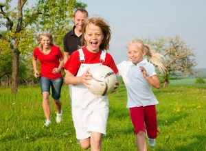 One child has grabbed the ball and is being chased by the others